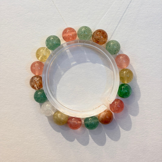 Handmade crystal bracelet with strawberry quartz, green aventurine, lemon citrine and clear quartz beads arranged on an elastic strand