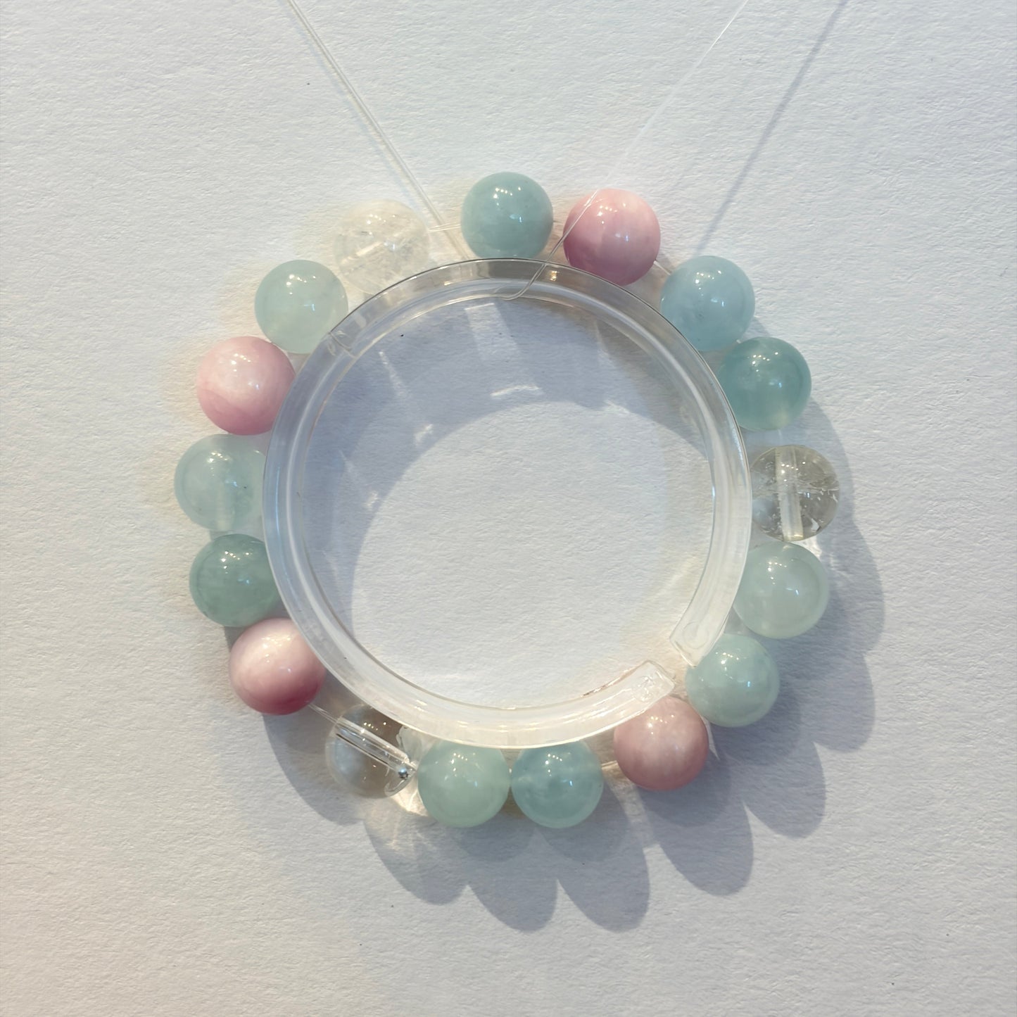 Handmade pastel crystal bracelet featuring light blue, pink, and clear gemstone beads on an elastic band